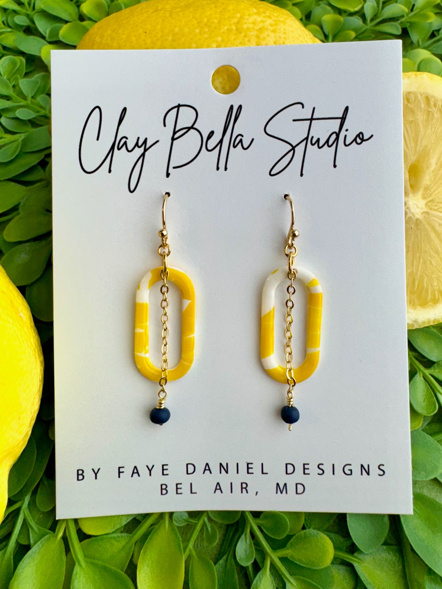 The Limoncello Oval Drop Earrings feature a lemon-patterned top with a chain and handmade bead.