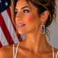 Woman wearing lightweight red, white, and blue polymer clay earrings in a silver frame