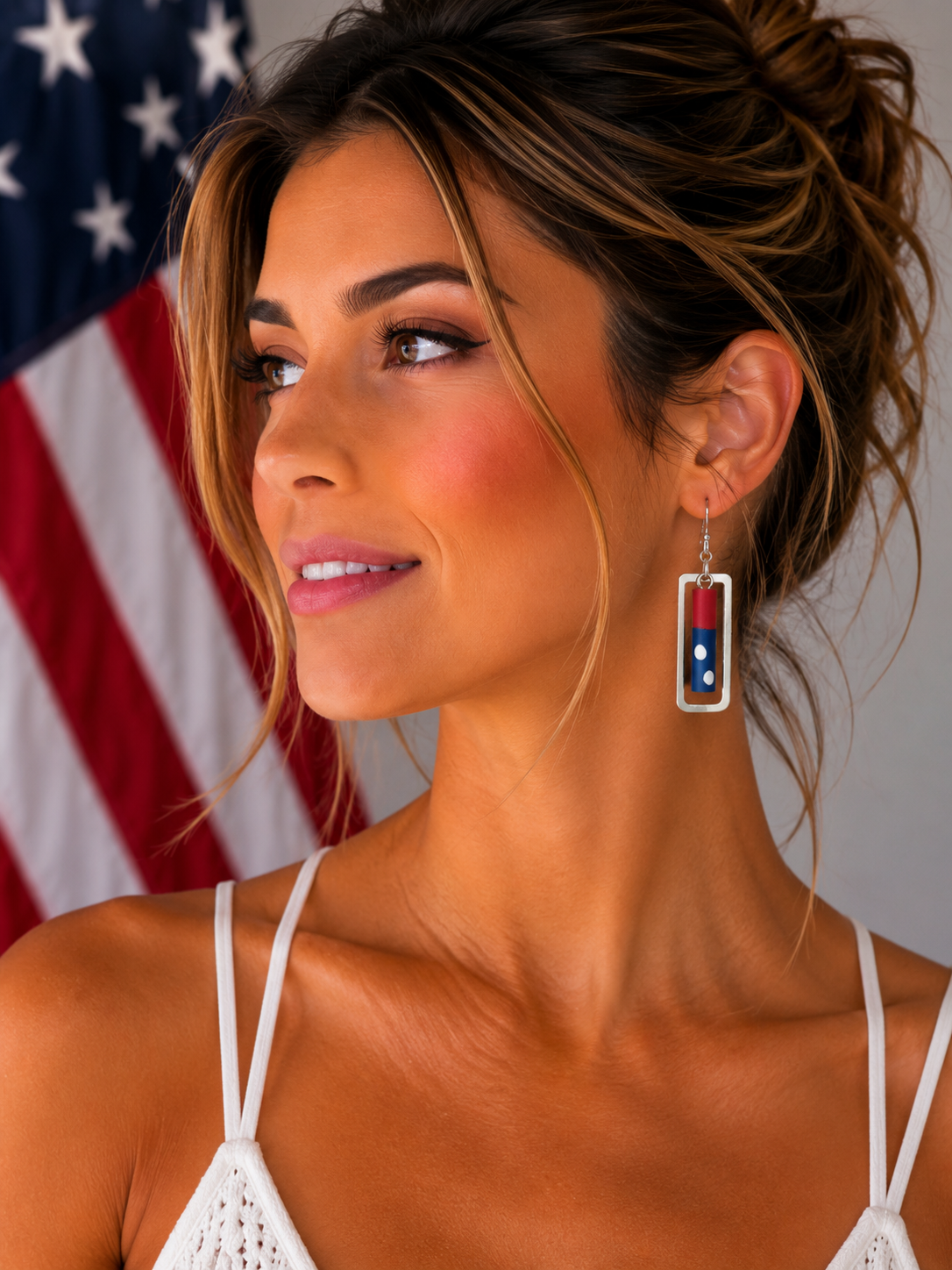 Woman wearing lightweight red, white, and blue polymer clay earrings in a silver frame